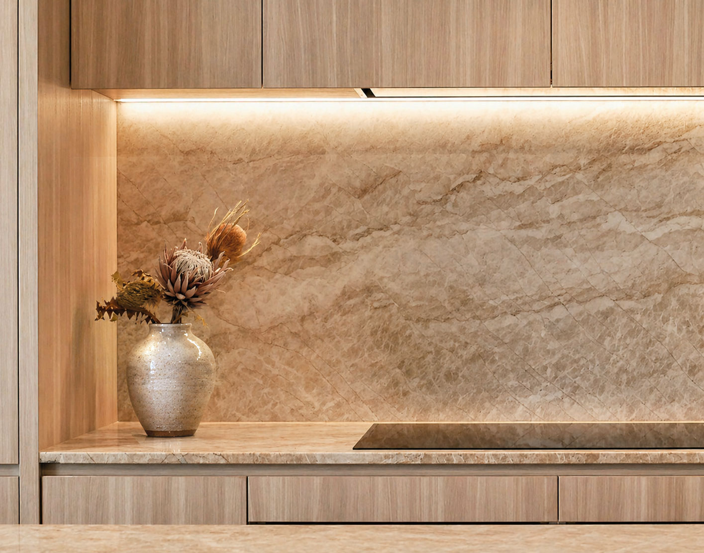 Backlit Taj Mahal stone splashback within timber kitchen joinery at Clara Residence