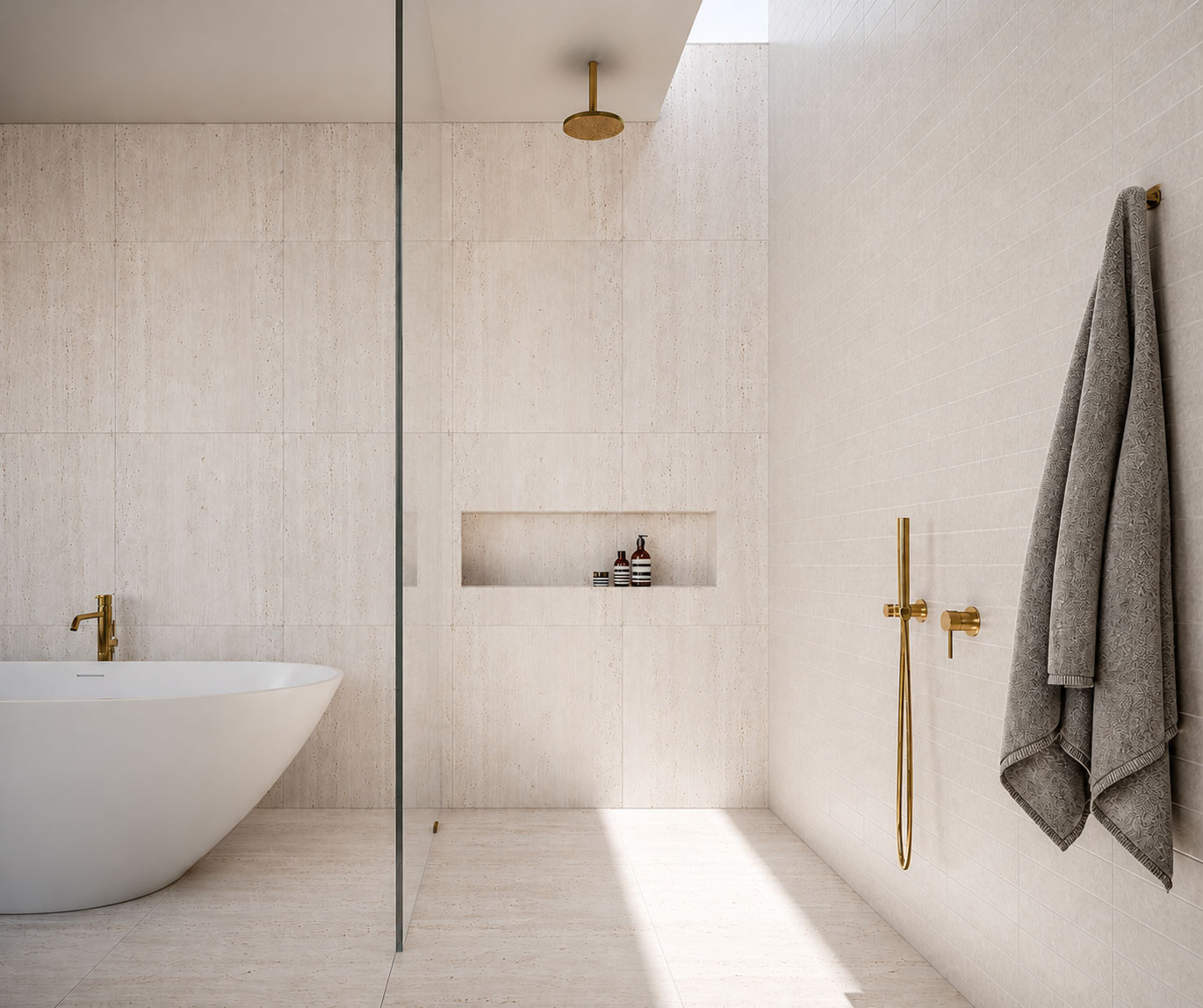 Travertine bathroom with freestanding bath and brass tapware