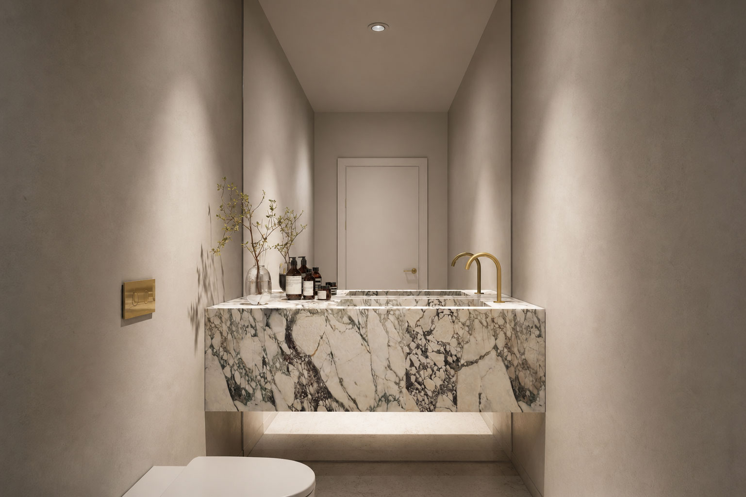 Sculptural marble vanity in a powder room with brass tapware